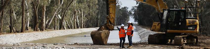 Employment Application Guidelines Photograph of two GMW employees in hard hats and high visibility vests in front of a digger contructing a channel